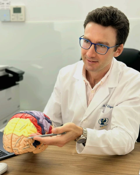 El Dr. Federico López señala sobre un modelo anatómico las zonas cerebrales que estimula la EMT